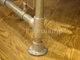 Clothing rail base up close on wooden floor. Using Interclamp steel clamp fittings 